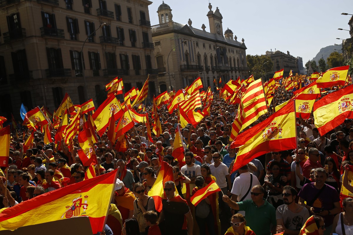 People wave Spanish and Catalan flags during a march in downtown Barcelona, Spain, to protest the Catalan government's push for secession from the rest of Spain, Sunday Oct. 8, 2017. Sunday' ...