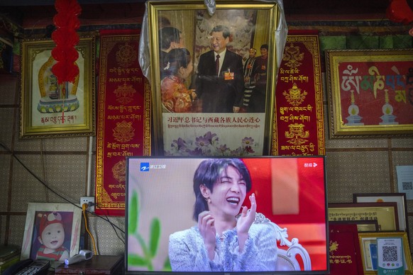 FILE - In this June 4, 2021, file photo, a television shows a broadcast of a Chinese talk show program as it sits beneath a photo of Chinese President Xi Jinping in a home converted into a tourist hom ...