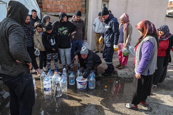 epa10476668 People wait to get fresh water from a tank after powerful earthquake in Adiyaman, Turkey, 19 February 2023. More than 45,000 people have died and thousands more are injured after two major ...