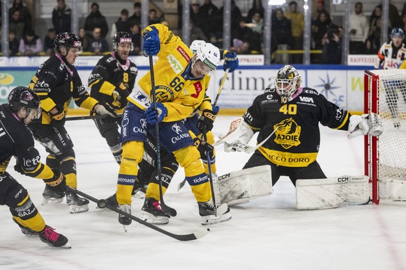 Der Jurassier im Dienst der Davoser, Valentin Nussbaumer (HCD), Mitte, bringt Unruhe vors Tor von Torhueter Damiano Ciaccio (HCA), rechts, im Spiel der Eishockey National League zwischen HC Ajoie, HCA ...