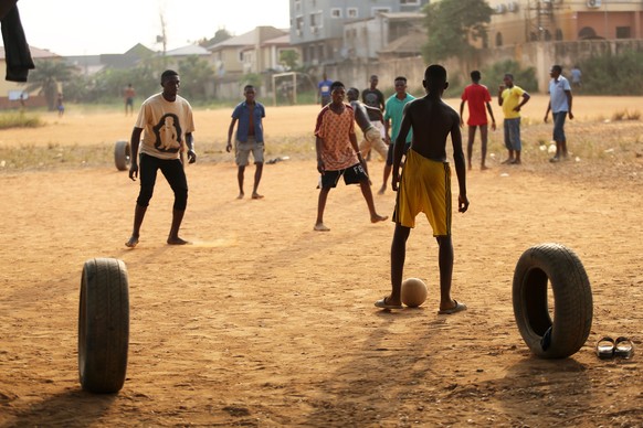 epa09674429 A makeshift goal post made of used tyres is seen as footballers play on a dusty field in the Ogudu district of Lagos, Nigeria, 08 January 2022. Many African football legends, including man ...