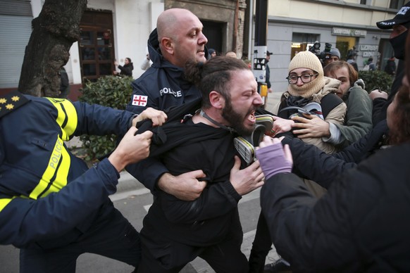 FILE - Police try to detain a protester during a rally against the results of the parliamentary elections amid allegations that the vote was rigged in Tbilisi, Georgia, on Nov. 19, 2024. (AP Photo/Zur ...