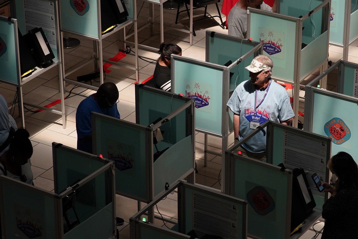 FILE - An election worker walks through voting booths to help as people vote at a polling place June 14, 2022, in Las Vegas. Voting could feel different in this year's midterms, as the election f ...