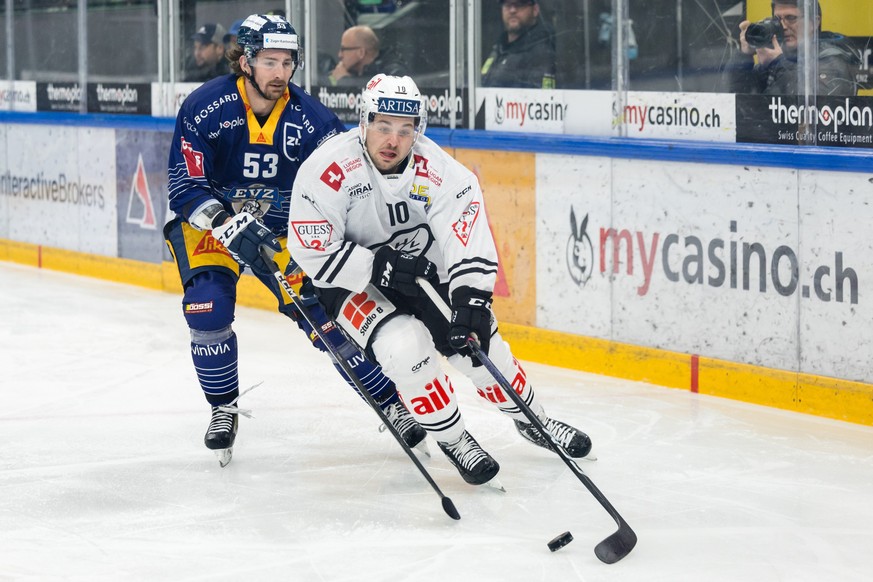 Luganos Marco Mueller, rechts, gegen Zugs Adam Almquist im Eishockey Qualifikationsspiel der National League zwischen dem EV Zug und dem HC Lugano am Freitag, 3. Februar 2023 in der Bossard Arena in Z ...