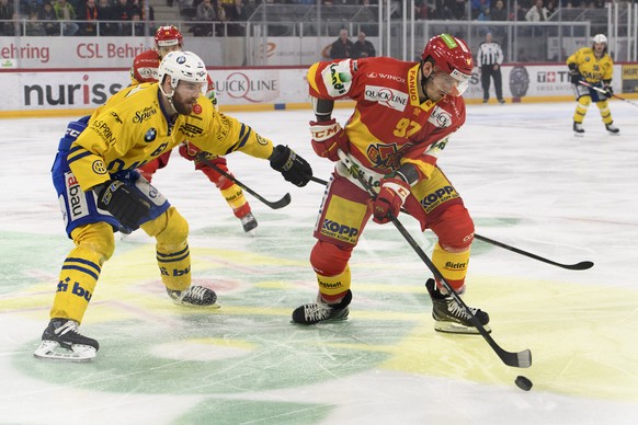 Davos Fabian Heldner, links, und Biels Mathias Joggi, rechts, kaempfen um den Puck, im ersten Eishockey Playoff-Viertelfinalspiel der National League zwischen dem HC Biel und dem HC Davos, am Samstag, ...