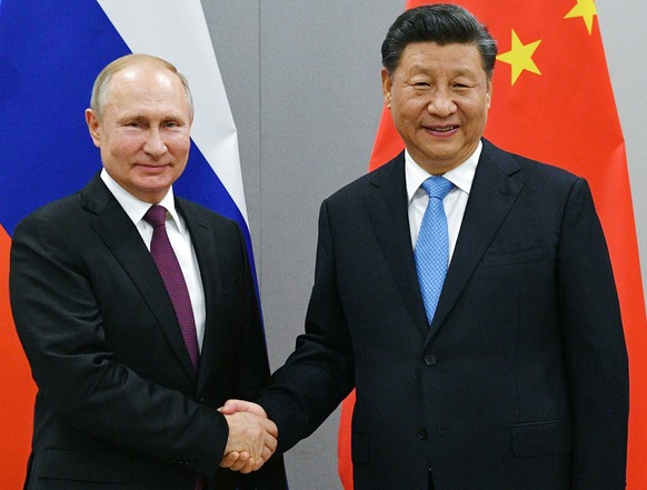 FILE - In this Nov. 12, 2019, file photo, Russian President Vladimir Putin, left, and China&#039;s President Xi Jinping shake hands prior to their talks on the sideline of the 11th edition of the BRIC ...