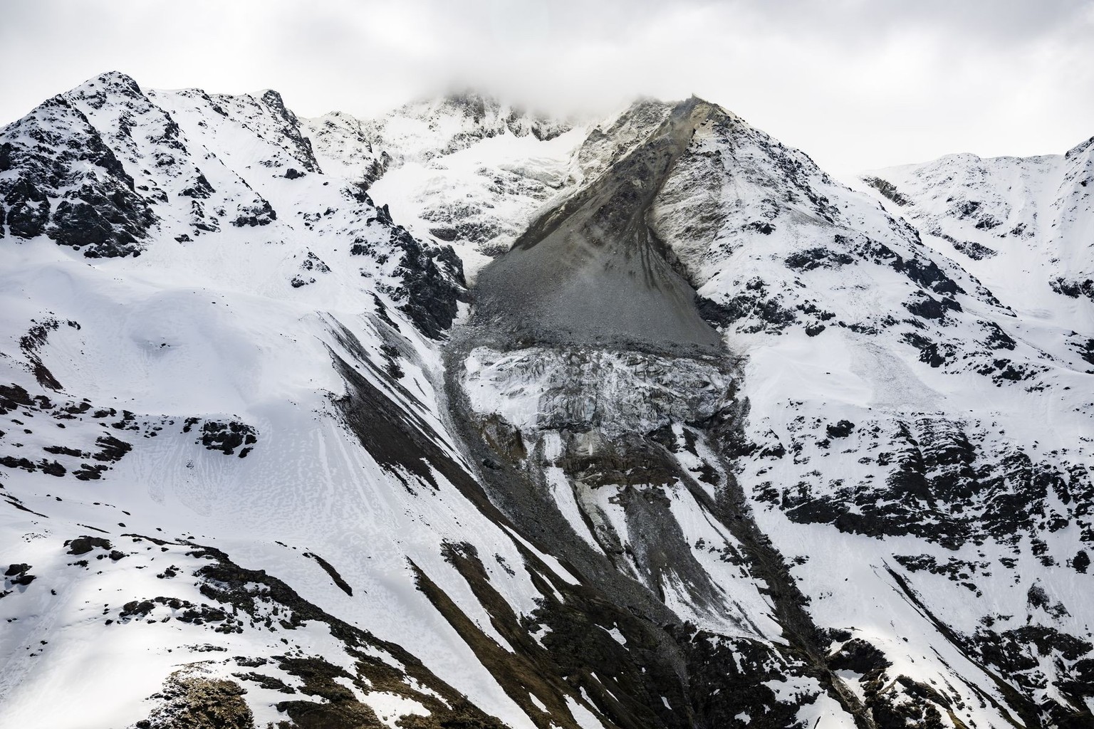 Steine eines Felssturzes vom Kleinen Nesthorn stuerzen auf den Birchgletscher im Loetschental, am Freitag, 23. Mai 2025, in Blatten. Das Dorf Blatten VS im Loetschental musste wegen der Gefahr eines F ...