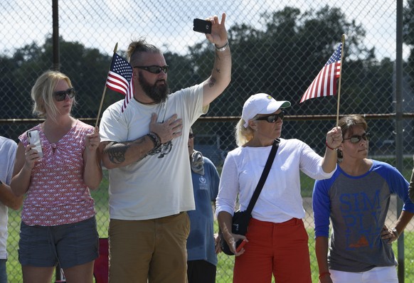 People watch as the funeral procession for Sen. John McCain, R-Ariz., arrives at the United States Naval Academy in Annapolis, Md., Sunday, Sept. 2, 2018, for his funeral service and burial. McCain di ...