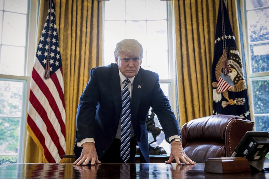 FILE - In this Friday, April 21, 2017, file photo, President Donald Trump poses for a portrait in the Oval Office in Washington. Trump will mark the end of his first 100 days in office with a flurry o ...