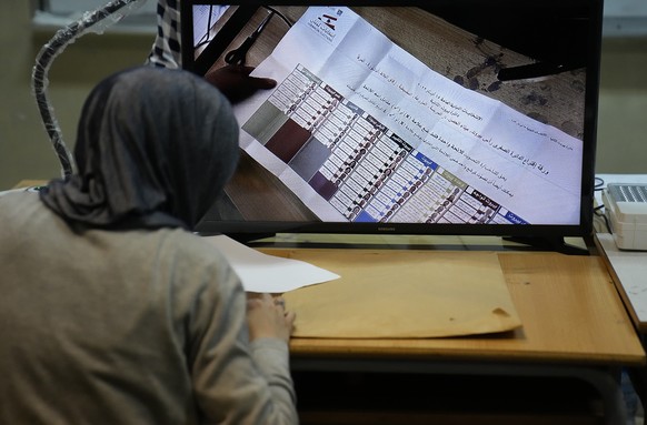 A candidate representative watches a screen displaying ballots after the close of a polling station at the end of the parliamentary election day, in Beirut, Lebanon, Sunday, May 15, 2022. Lebanese vot ...