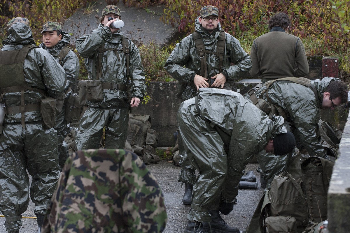 Des militaires de l'armee Suisse s'equipent de leur combinaison NBC lors de la presentation de l'exercice D-CH ABC FTX14, ce lundi 17 novembre 2014, au village d'excercice d'E ...