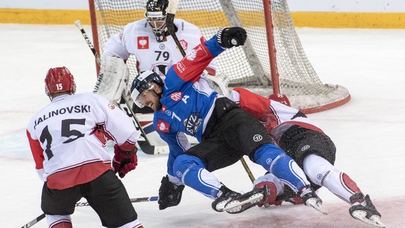 David McIntire, centre, from Zug and Roman Malinovsky, left, from Grodno, during the Champions Hockey League group D match between Switzerland&#039;s EV Zug and Neman Grodno of Belarus, in Zug, Switze ...