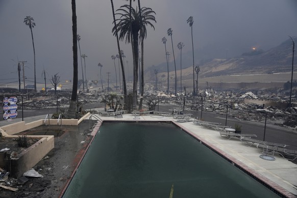 A pool is surrounded by charred ruins after a fire swept through the Pacific Palisades neighborhood of Los Angeles, California, Jan. 8, 2025. (AP Photo/Damian Dovarganes)