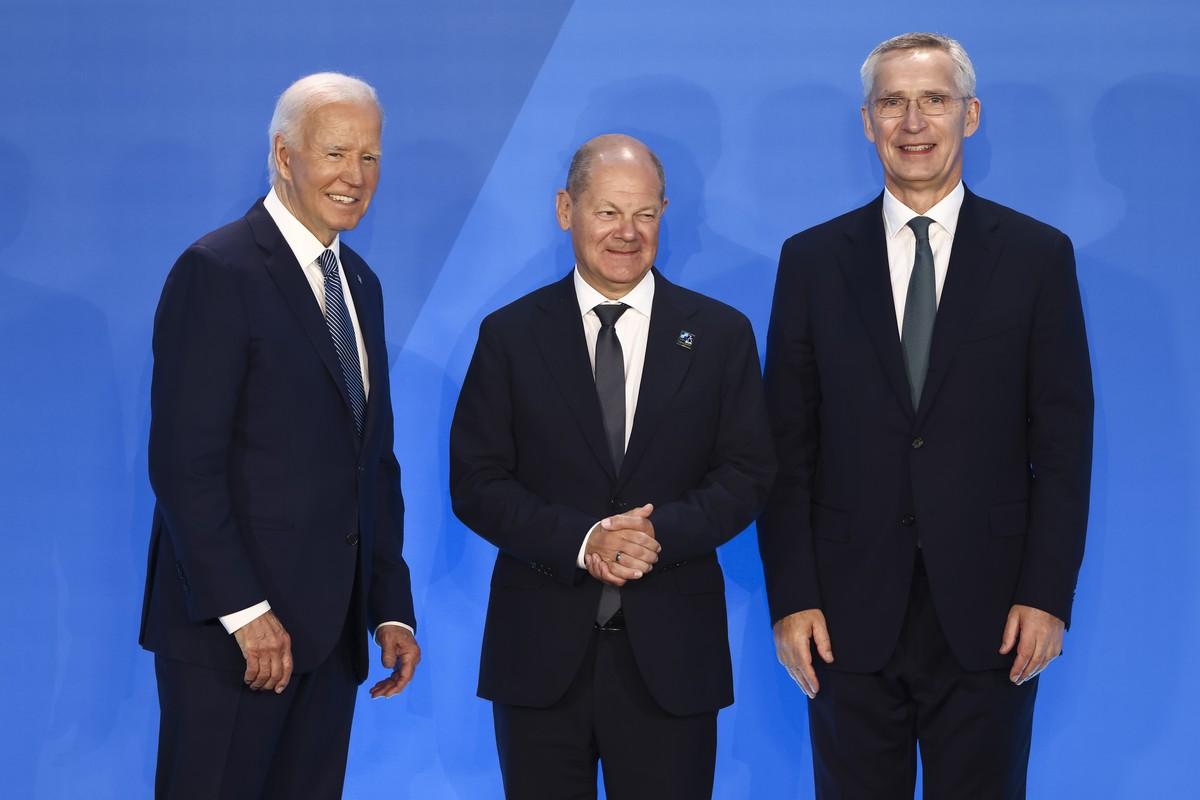 epa11470630 Germany?s Chancellor Olaf Scholz (C) stands with US President Joe Biden (L) and NATO Secretary General Jens Stoltenberg (R), during the welcome ceremony for NATO?s 2024 annual meeting in W ...