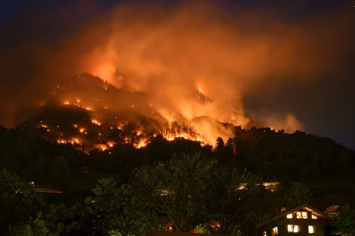 De la fumee et des flammes s'echappent de la foret en feu au dessus des communes de Bitsch et Ried-Moerel ce lundi 17 juillet 2023 depuis Naters. Un incendie de foret s'est declare lundi au- ...