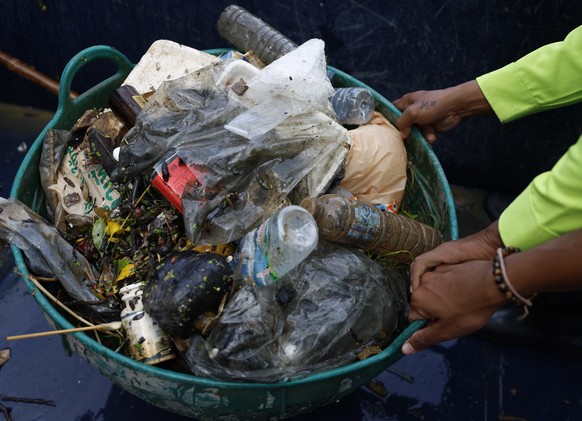 epa12386661 Garbage collectors from the Bangkok Metropolitan Administration&#039;s Drainage and Sewerage Department drag a garbage basket after collecting from Khlong Prem Prachakorn canal in Bangkok, ...