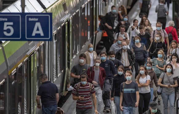 Die Zugsreisenden mit Schutzmasken verlassen einen Zug waehrend der Corona-Pandemie am Montag, 6. Juli 2020 im Bahnhof Luzern. (KEYSTONE/Urs Flueeler).