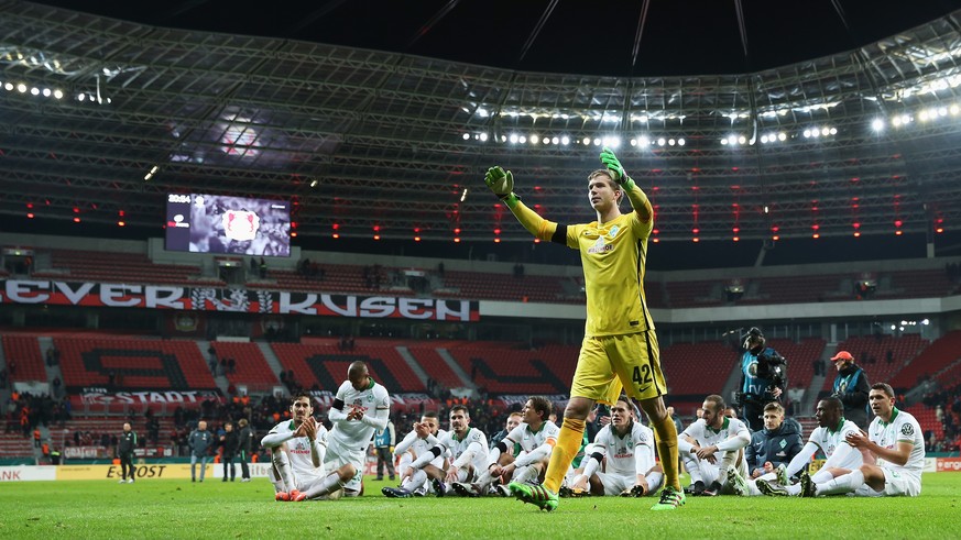 Die Weser-Elf feiert mit den eigenen Fans im ansonsten leeren Leverkusener Stadion.