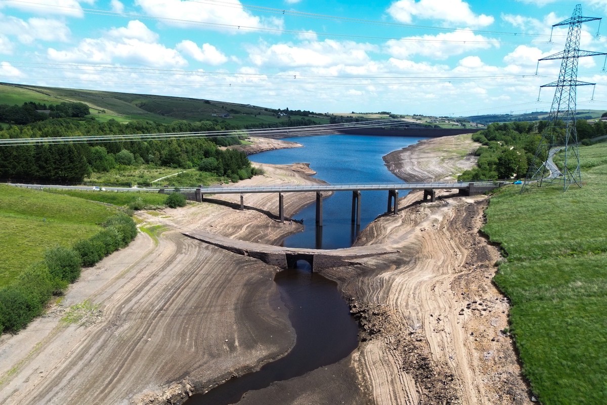 epa12206296 An aerial photograph taken with a drone of an ancient packhorse bridge revealed by low water levels at Baitings Reservoir in Ripponden, Britain, 30 June 2025. The bridge, thought to date f ...