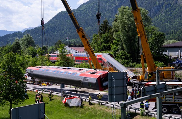 04.06.2022, Bayern, Garmisch-Partenkirchen: Die Rettungskr�fte haben nach einem schweren Zugungl�ck einen der Waggons angehoben und legen ihn auf die Stra�e. Bei dem Ungl�ck sind mindestens vier Mensc ...