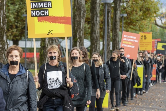 Demonstranten marschieren beim walk for Freedom in einer Einerkolonne gegen Menschenhandel und moderne Sklaverei bei einer Aktion am Samstag, 15. Oktober 2022 in Luzern. (KEYSTONE/Urs Flueeler)