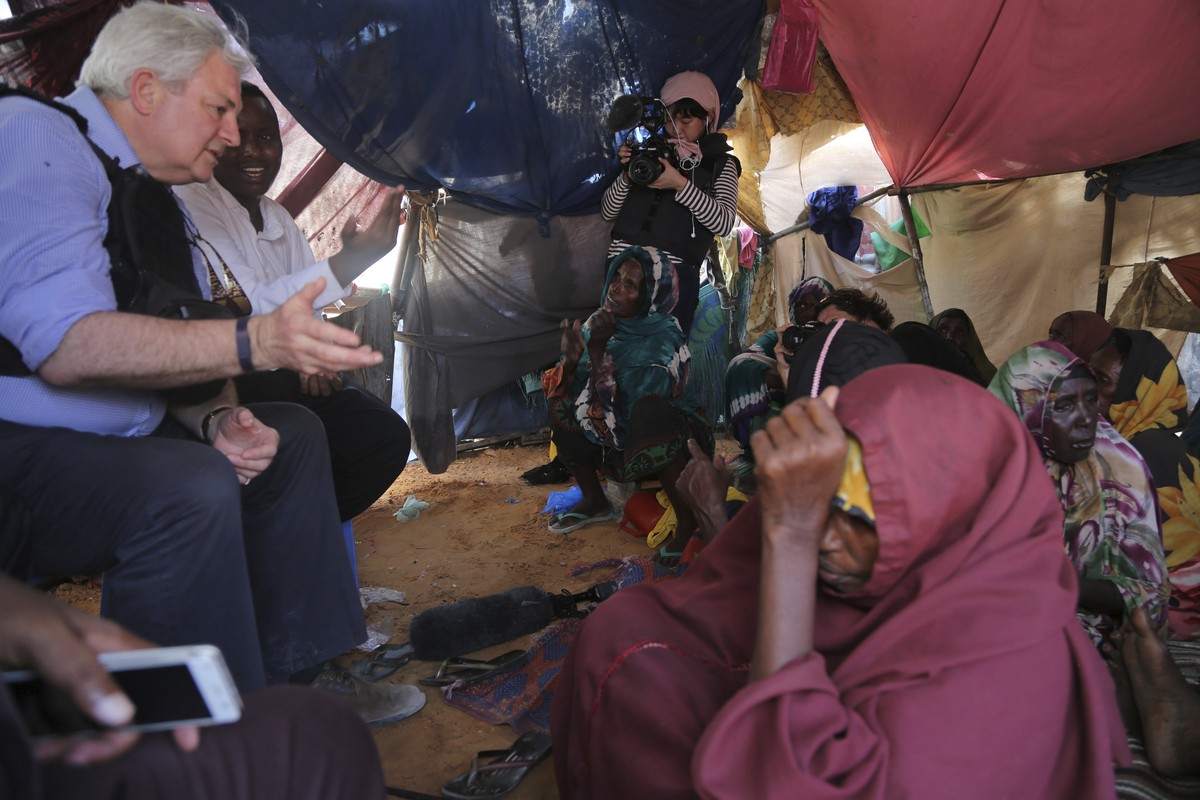 UN Humanitarian Chief Stephen O'Brien, left, meets with drought affected people in one of Mogadishu's IDP camps in Somalia, Monday, March 6, 2017, during his visit to Somalia.(AP Photo/Moham ...
