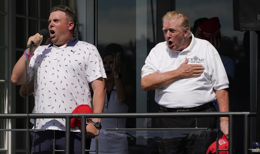 ADDS NAME DAN FRANKEL - Former President Donald Trump, right, reacts as Dan Frankel sings &quot;God Bless America&quot; at the 16th tee during the second round of the Bedminster Invitational LIV Golf  ...