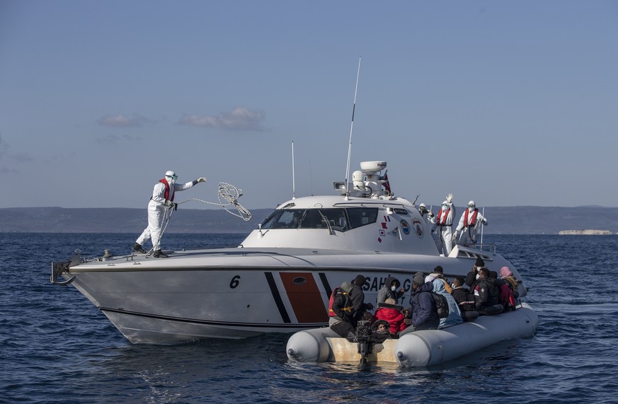 epa09131056 Members of the Turkish Coast Guard take migrants, who were allegedly pushed back from the Greece side, on a boat during a patrol to search and rescue for migrants offshore the Ayvalik dist ...