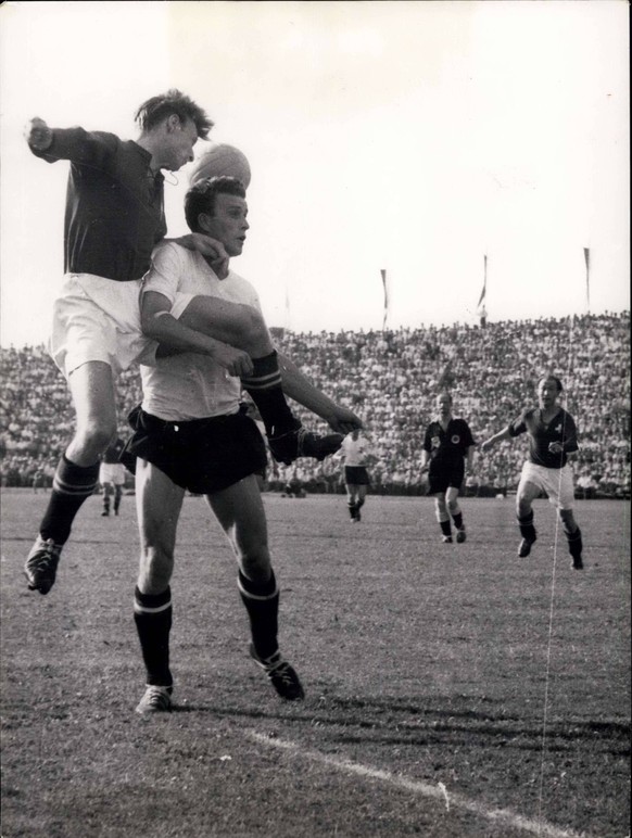 Jun. 26, 1954 - Swiss - Austria in Lausanne 5 : 7: A double foul , as picture shows. The swiss forward Charles Antenen is holding his opponent while the other is keeping his leg tight. The arbitrator  ...