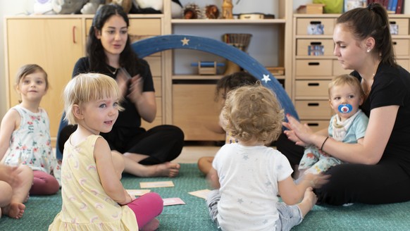 ARCHIV - ZUR ABLEHNUNG DER KITA INITIATIVE DURCH DEN BUNDESRAT - Kinder sitzen gemeinsam mit Betreuungspersonal der Kita 6a der Stiftung GFZ im Kreis und machen Spiele, aufgenommen am 9. Juli 2020 in  ...