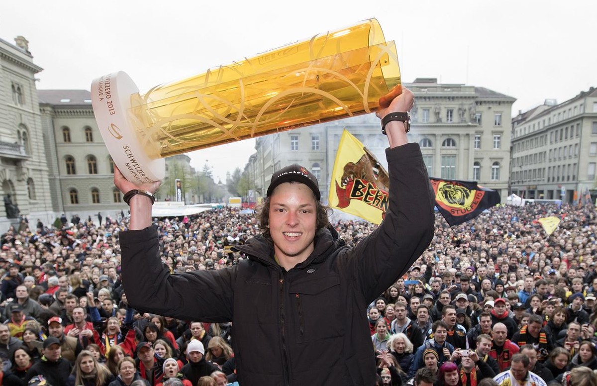 Kevin Loetscher haelt den Meisterpokal hoch bei der Meisterfeier des SCB am Samstag, 20. April 2013 auf dem Bundesplatz in Bern. (KEYSTONE/Peter Klaunzer)