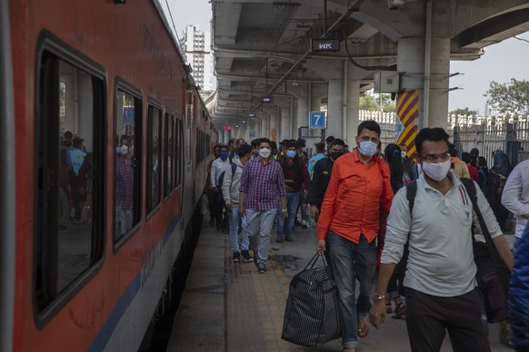 Passengers wearing face masks as a precaution against coronavirus arrive at a train station in Mumbai, India, Thursday, Dec 30 , 2021. (AP Photo/Rafiq Maqbool)