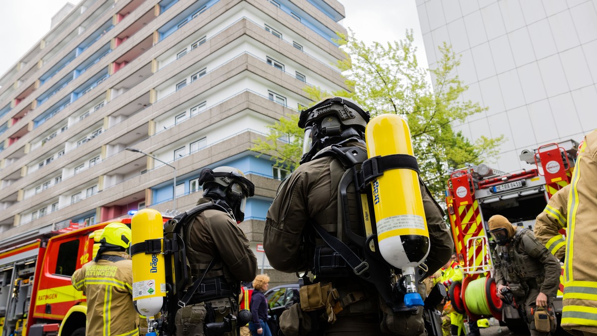 11.05.2023, Nordrhein-Westfalen, Ratingen: Polizeibeamte mit Gasmasken und Feuerwehrleute stehen vor einem Hochhaus. Bei einer Explosion in einem Hochhaus in Ratingen am Donnerstagvormittag wurden meh ...