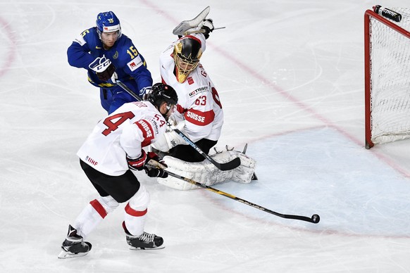 epa05972943 Switzerlandâs goaltender Leonardo Genoni (R) and Philippe Furrer (front) in action against Swedenâs Oscar Lindberg during the IIHF Ice Hockey World Championship 2017 quarter final game ...