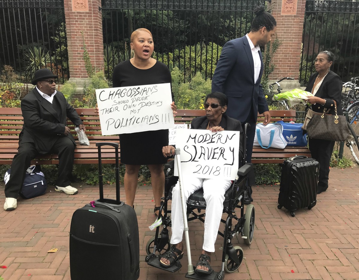 Protesters hold placards outside the World Court in The Hague, Netherlands, Monday, Sept. 3, 2018. Judges at the United Nations' highest court are listening to arguments in a case focused on whet ...