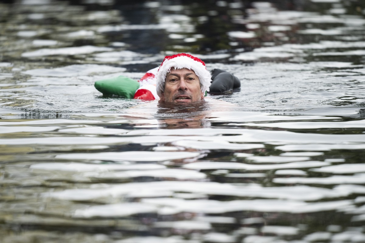 epa11060672 A man takes part in the Befana Swimming in Brissago, Switzerland, 06 January 2024. During the traditional 'Nodada de la Befana', the Lago Maggiore in the port of Brissago is trav ...