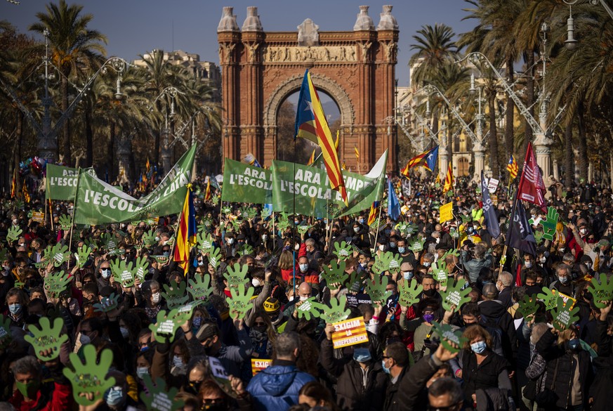 Demonstrators march holding banners and shouting slogans demanding the use of Catalan in schools of Catalonia, in Barcelona, Spain, Saturday, Dec. 18, 2021. Thousands of Catalans took to the streets o ...