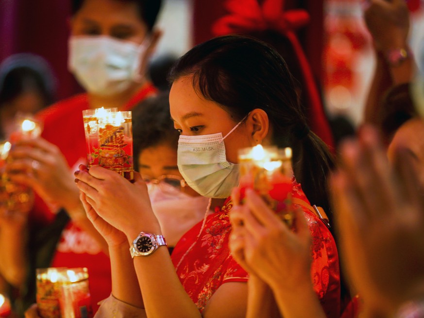epa10422206 People burn candles to welcome the Chinese Lunar New Year at a Chinese Buddhist temple in Chinatown, Bangkok, Thailand, 22 January 2023. The Chinese lunar new year, or Spring Festival as i ...