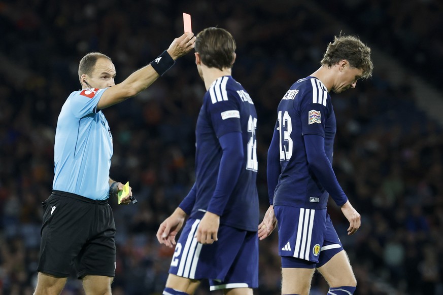 Serbia's referee Nenad Minakovic, left, gives a red card to Scotland's Jack Hendry, right, during the UEFA Nations League soccer match between Scotland and Switzerland at the Hampden Park in ...