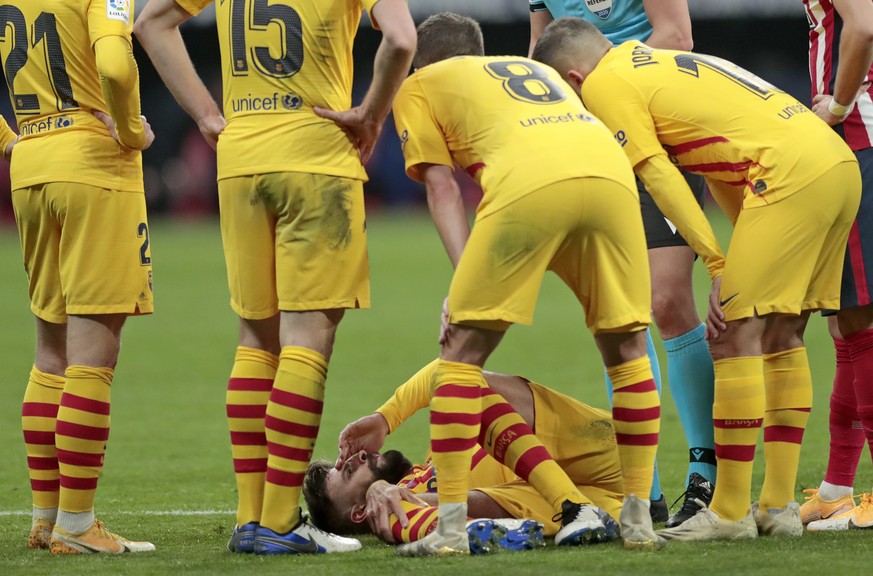 Barcelona&#039;s Gerard Pique, bottom, reacts after getting an injury during the Spanish La Liga soccer match between Atletico Madrid and FC Barcelona at the Wanda Metropolitano stadium in Madrid, Spa ...