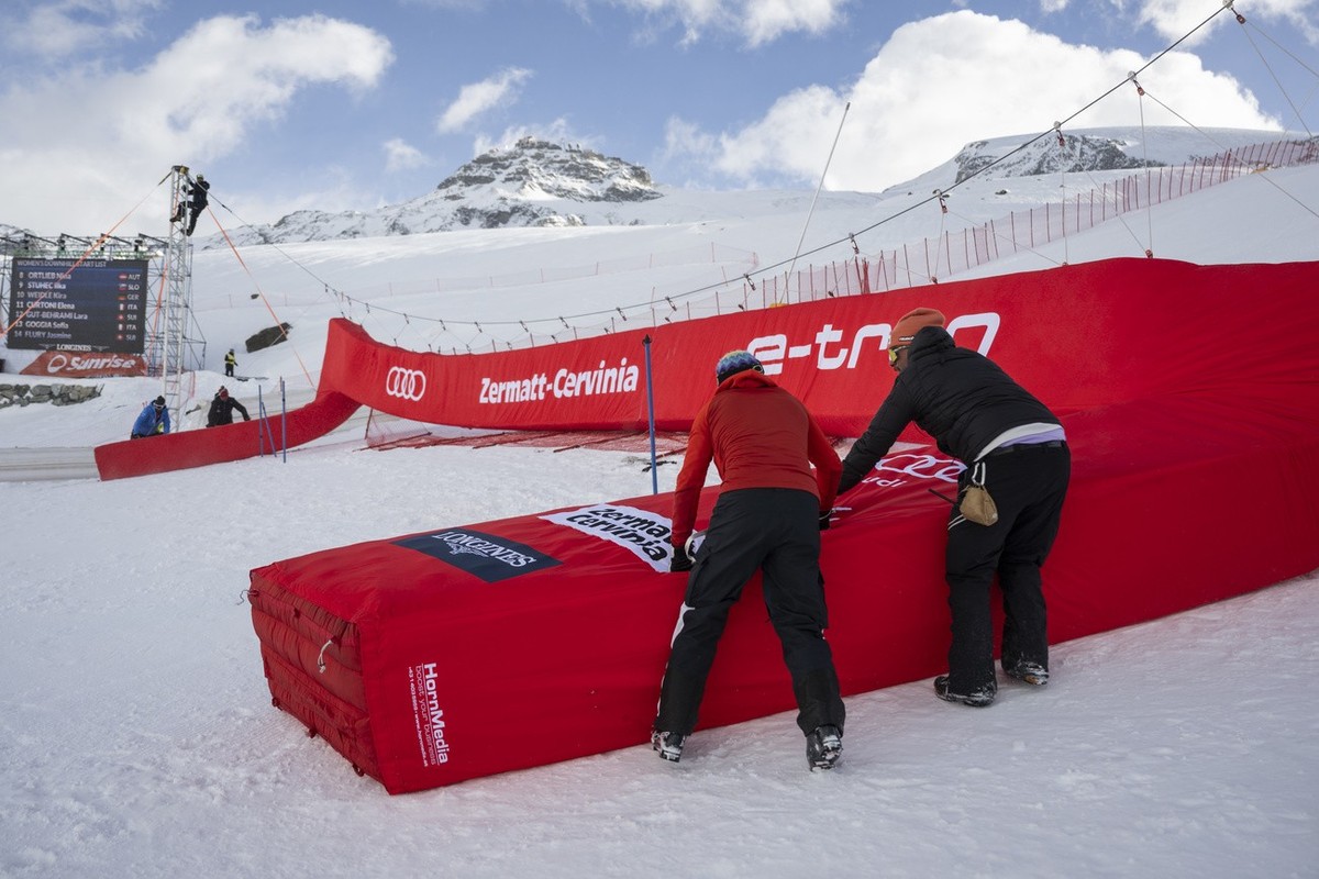 Volunteers mount the finish gate, ahead of the women's downhill race on the new ski course "Gran Becca" at the Alpine Skiing FIS Ski World Cup Zermatt-Cervinia, in Cervinia, Italy, Sund ...