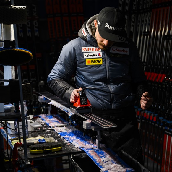 Simon Vicenzi, a Swiss-ski service technician, uses an iron to melt wax on a ski during ski preparation for an athlete using the Stoeckli brand at the Alpine Skiing FIS Ski World Cup, in St. Moritz, S ...