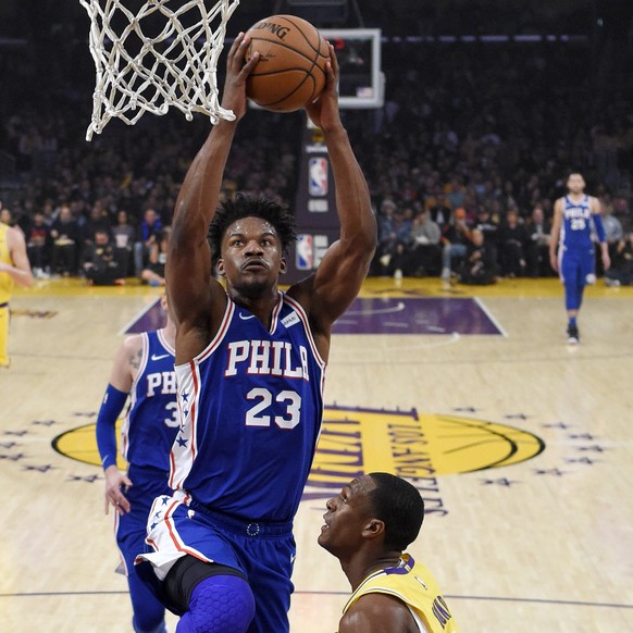 Philadelphia 76ers guard Jimmy Butler, left, goes up for a dunk as Los Angeles Lakers guard Rajon Rondo defends during the first half of an NBA basketball game Tuesday, Jan. 29, 2019, in Los Angeles. ...
