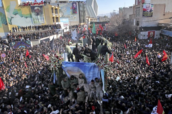 Coffins of Gen. Qassem Soleimani and others who were killed in Iraq by a U.S. drone strike, are carried on a truck surrounded by mourners during a funeral procession, in the city of Kerman, Iran, Tues ...