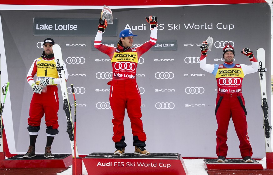 First place finisher Matthias Mayer, of Austria, celebrates on the podium with second place finisher Austria&#039;s Vincent Kriechmayr, left, and third place finisher Switzerland&#039;s Beat Feuz afte ...