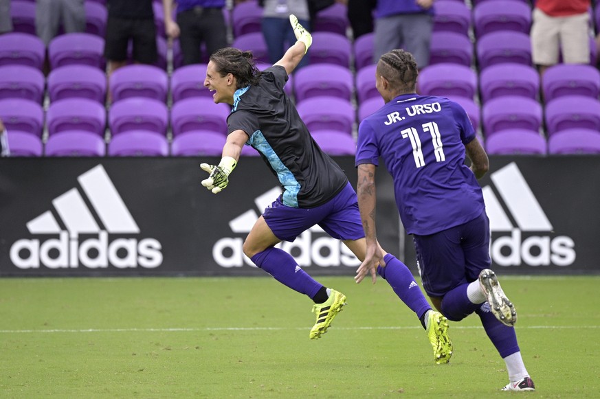 Orlando City defender Rodrigo Schlegel, left, celebrates after blocking the final New York City FC penalty kick during overtime of an MLS soccer playoff match, Saturday, Nov. 21, 2020, in Orlando, Fla ...