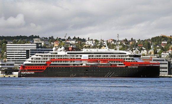 epa08579015 A general view on the expedition ship MS Roald Amundsen at a quay and the hotel The Edge, where passengers of the ship were locate, in Tromso, Norway, 01 Agust 2020. According to reports,  ...