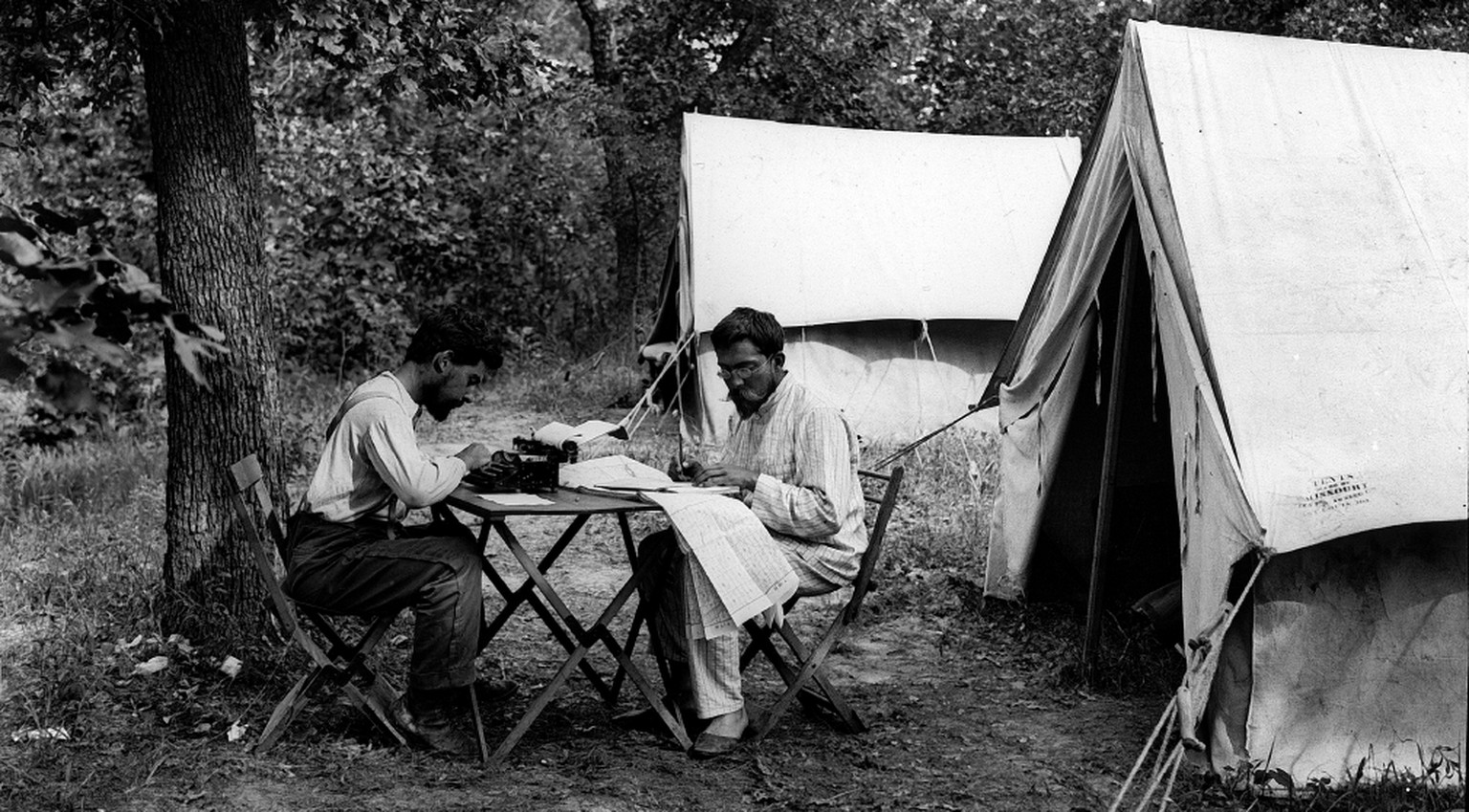 Fotograf:
Heim, Arnold 
Titel:
Camp 6, Ausarbeiten der Rapporte. E. Blösch und Arnold Heim 
Beschreibung:
Zwei Männer am Tisch vor Zelt, Bäume 
Datierung:
5/1912