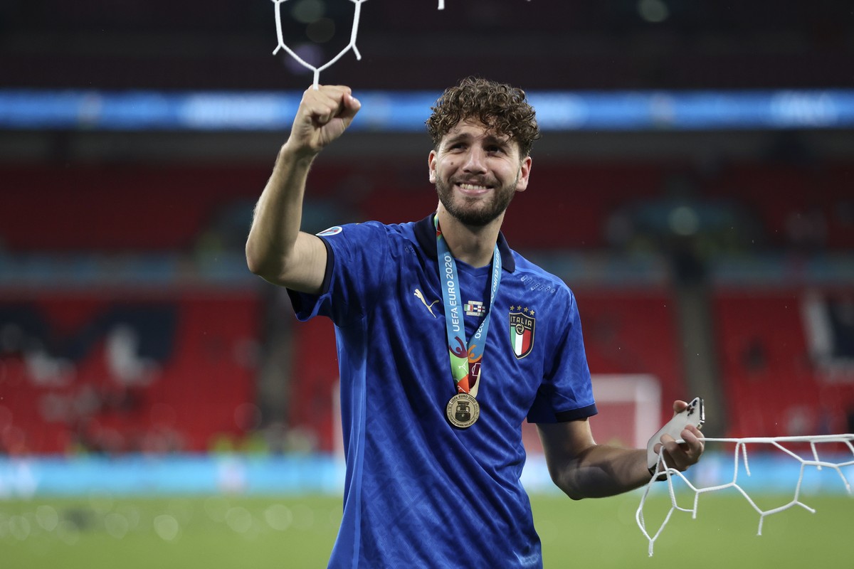 Italy's Manuel Locatelli celebrates while holding a piece of the goal net after Italy won the Euro 2020 soccer championship final match between England and Italy at Wembley stadium in London, Sun ...