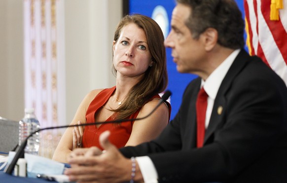 epa08445188 Melissa DeRosa (L), Secretary to New York Governor Andrew Cuomo, listens as Cuomo speaks during his daily briefing in a conference room at the New York Stock Exchange in New York, New York ...